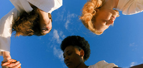 three women looking happy with the sky behind them