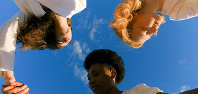 three women looking happy with the sky behind them