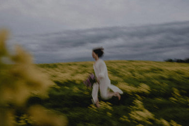 Person sitting in a field with a blurred background